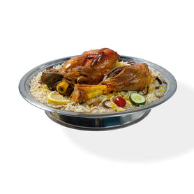 Abu Mubarak Combo 3 Mandi for four people, featuring two large slow-cooked lamb shanks and two portions of roast chicken on a grand bed of aromatic yellow and white smoked basmati rice, garnished with lemon and fresh vegetables.
