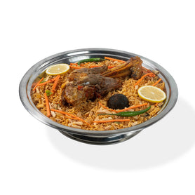 A single serving of Abu Mubarak Lambshank Kabsa featuring a large, tender slow-cooked lamb shank on a bed of aromatic spiced basmati rice, garnished with fresh vegetables and lemon.
